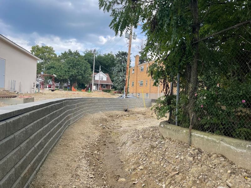Block retaining wall and graded dirt drainage path